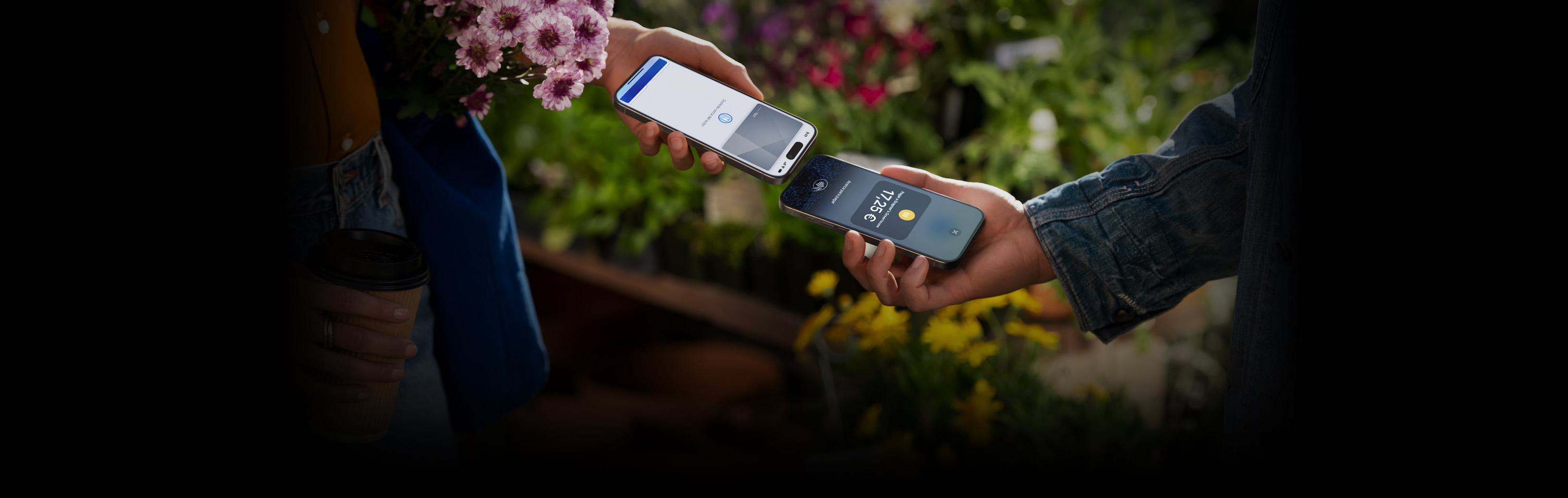 Una imagen de dos personas sosteniendo sus dispositivos iPhone cerca para completar una transacción.