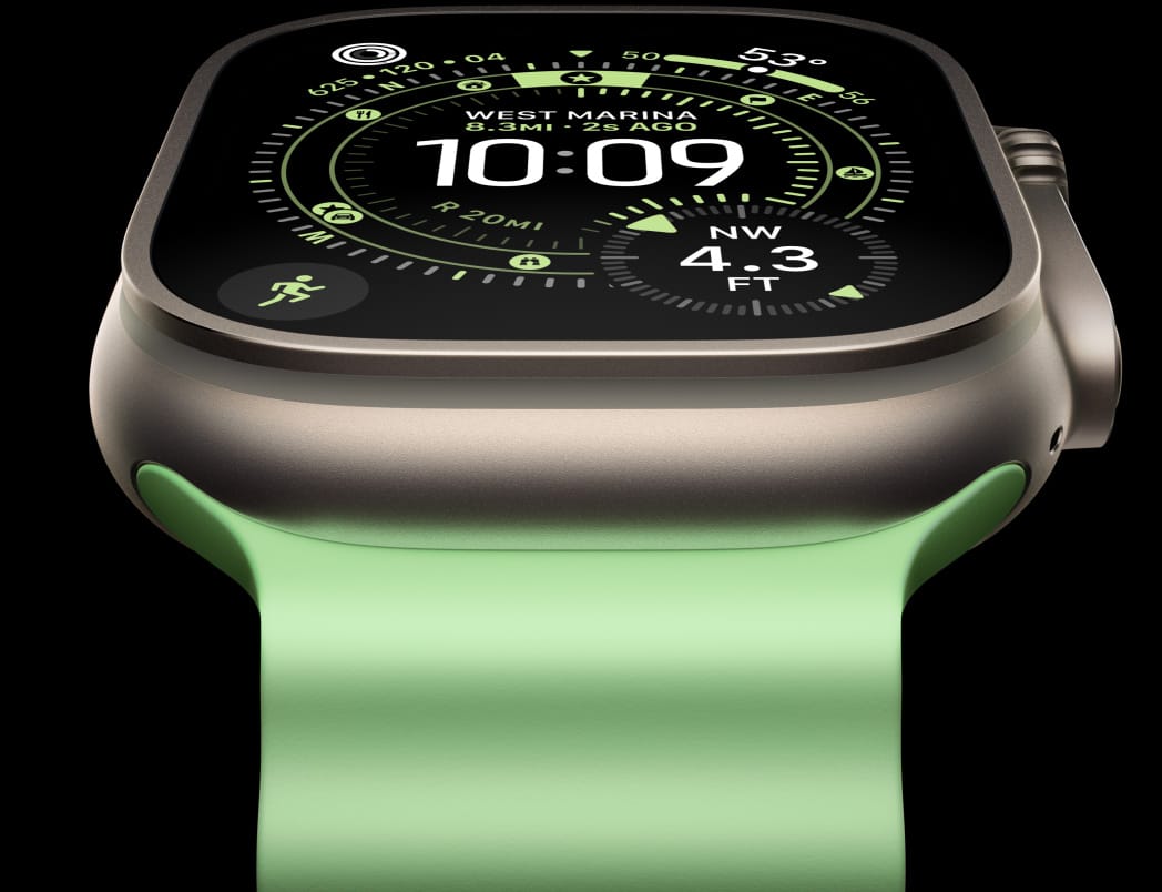 Apple Watch Ultra 3 med urkasse av naturlig titan og Ocean Band i neongrønn. På Orientering-urskiven vises et kompass.