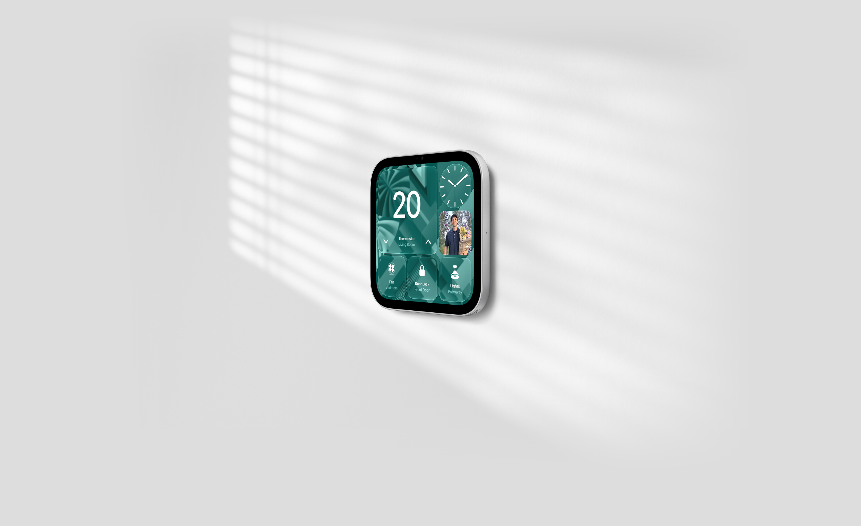 Apple HomeView, wall-mounted model on a wall, silver color, displaying time, temperature, front door camera feed and controls for thermostat, bedroom fan, door lock, and lights