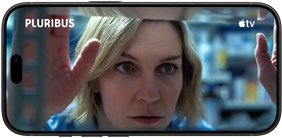  جهاز iPhone&nbsp;18&nbsp;Pro، الوضع الأفقي، يعرض لقطة مقرّبة لسيدة تنظر عبر النافذة. عنوان المسلسل: Pluribus‏‏