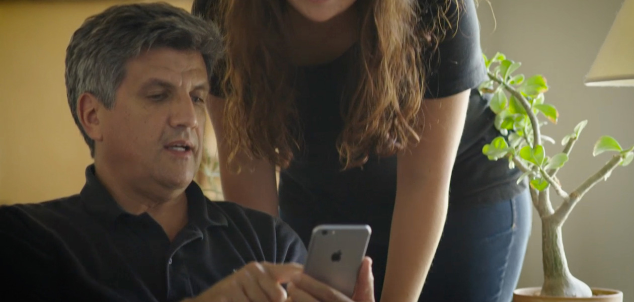 A man sharing his health information on an iPhone with a woman next to him.