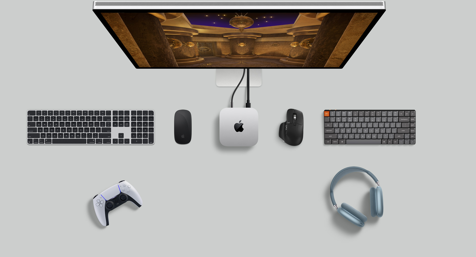 Ülaltvaade hõbedasele Mac minile laua peal koos monitori, juhtmevabade klaviatuuride, juhtmevaba hiire, mängupuldi ja AirPods Maxidega